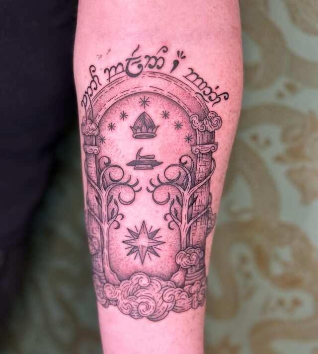 Tattoo of the Doors of Durin from The Lord of the Rings, an Elvish inscription arched over a doorway of trees and stars, on a forearm